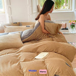 Frau sitzt auf dem Bett mit beigem Fleece-Bettbezug und liest ein Buch.