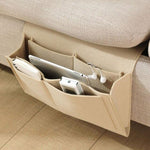 Beige BedCaddy, der an der Seite einer beigen Couch hängt, mit einem iPad und einem Telefon darin