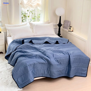 Coolwave Kühldecke in der Farbe dunkelblau auf einem gemachten Bett