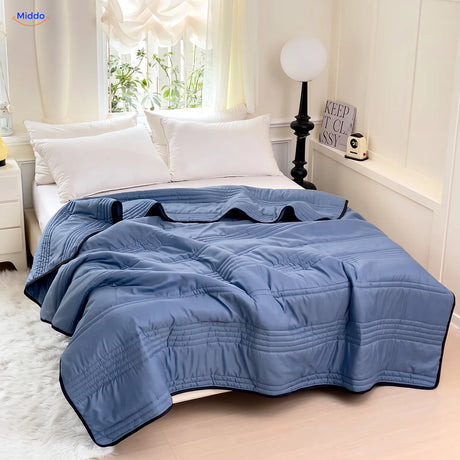 Coolwave Kühldecke in der Farbe dunkelblau auf einem gemachten Bett