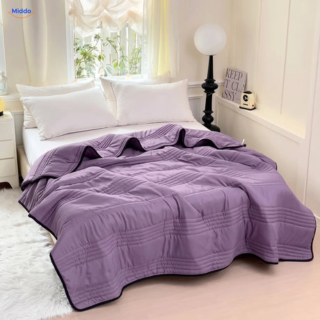 Coolwave Kühldecke in der Farbe lila auf einem gemachten Bett