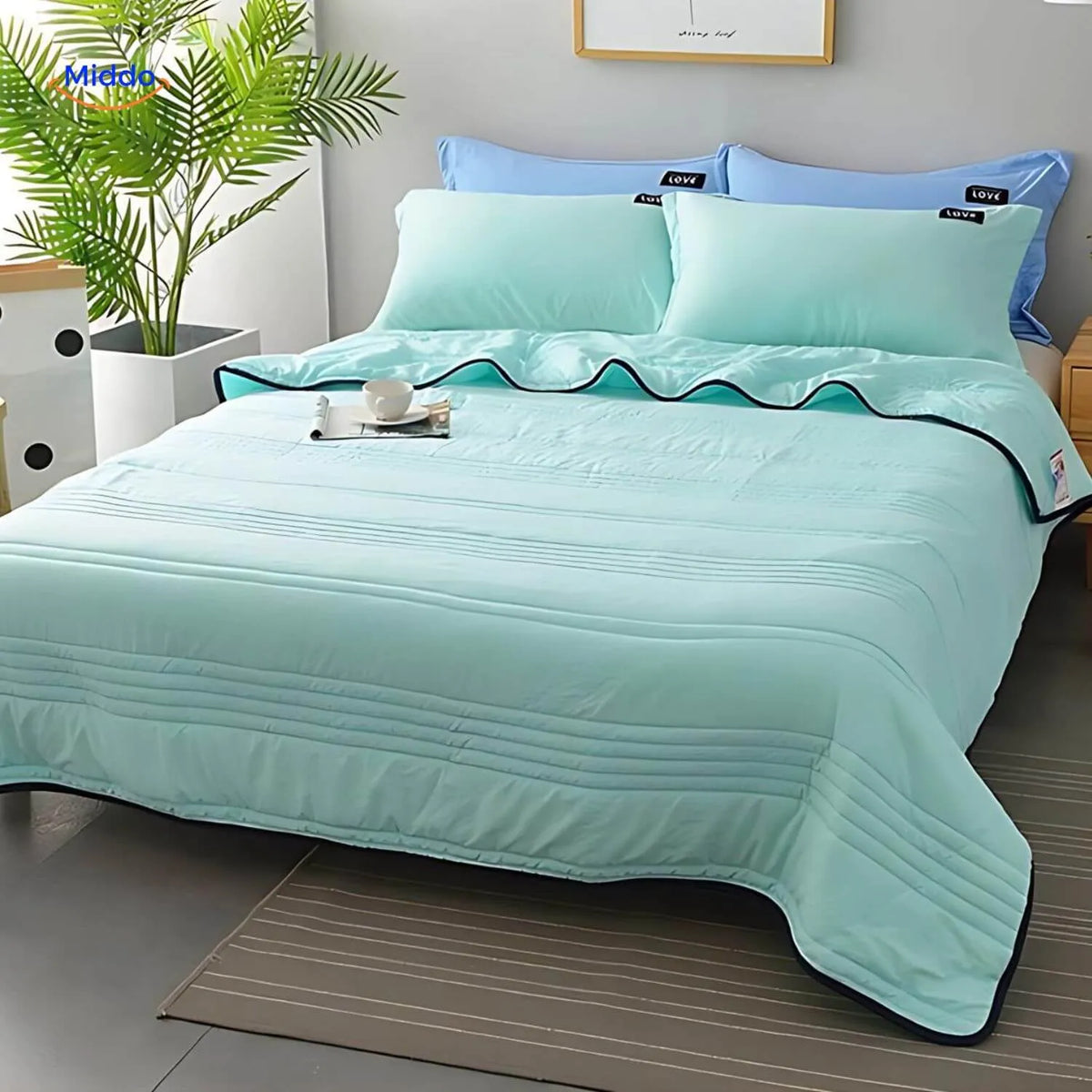 Coolwave Kühldecke in der Farbe wasser grün auf einem gemachten Bett