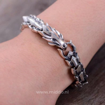 Silberne Drachenarmband um ein Handgelenk, Nahaufnahme des detaillierten Drachen Designs