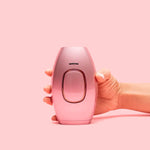 Hand hält DYLA IPL Haarentferner rosa Modell.