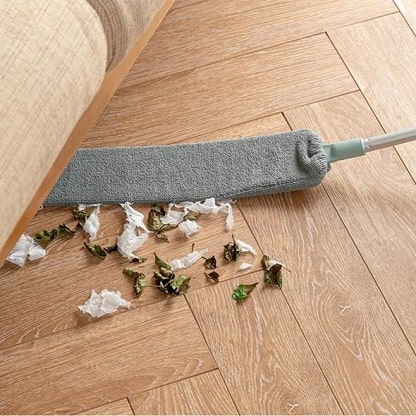 Ausziehbarer Staubtuch unter dem Sofa mit Schmutz.