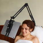 Frau liegt im Bett und benutzt einen FlexArm Tablethalter, um bequem ein Tablet zu schauen