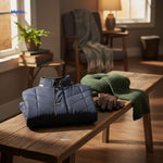 Froston Jacke gefaltet auf einem Tisch mit Schal und Handschuhen - www.middo.de