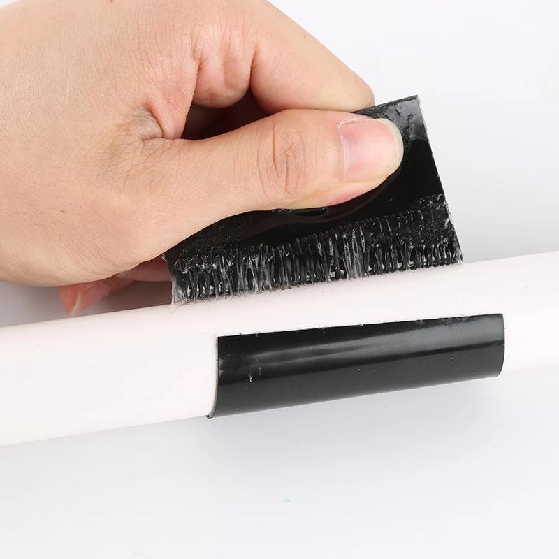 Hand bringt das schwarze wasserfeste Klebeband auf einem Rohr an.