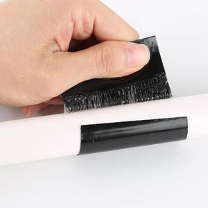 Hand bringt das schwarze wasserfeste Klebeband auf einem Rohr an