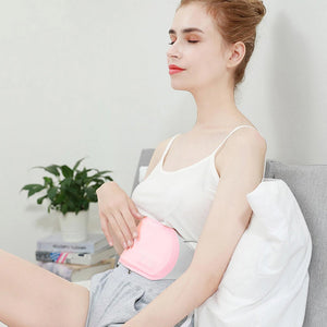 Eine Frau verwendet das Huggy Heizkissen zur Linderung von Menstruationskrämpfen