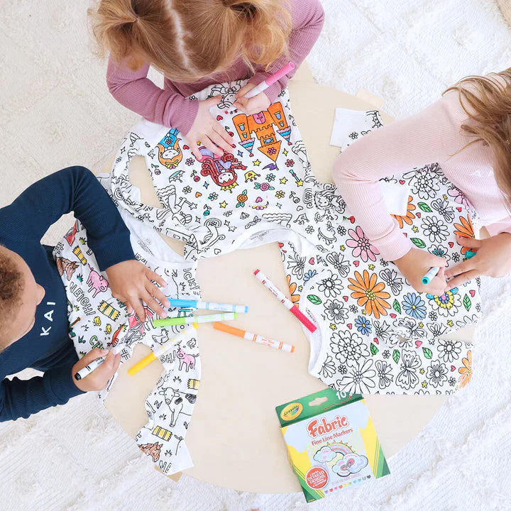 Kinder malen an einem Tisch anziehbare Schlafanzüge aus.