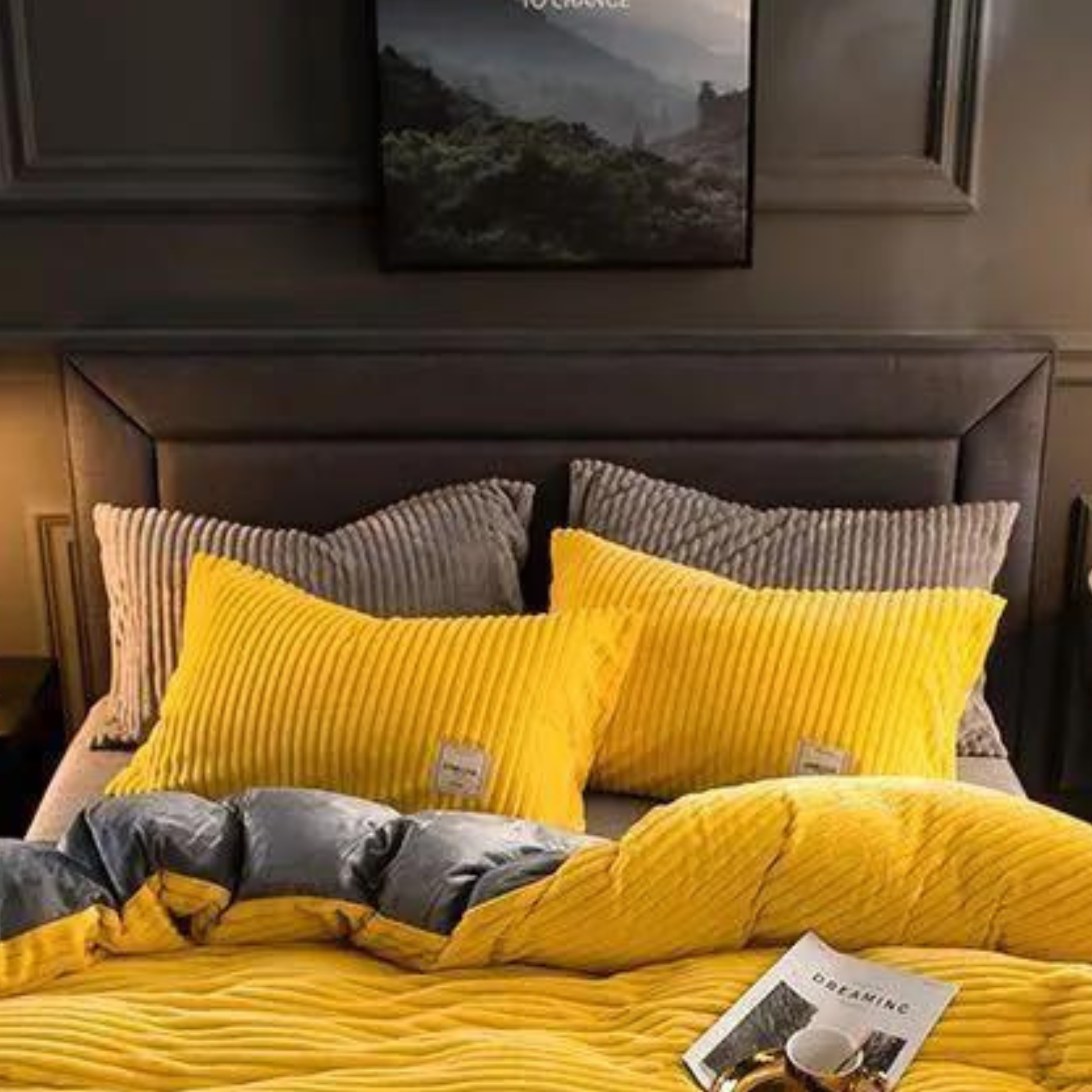 Gelbe und graue Samt-Kissenbezüge auf einem gemachten Bett.