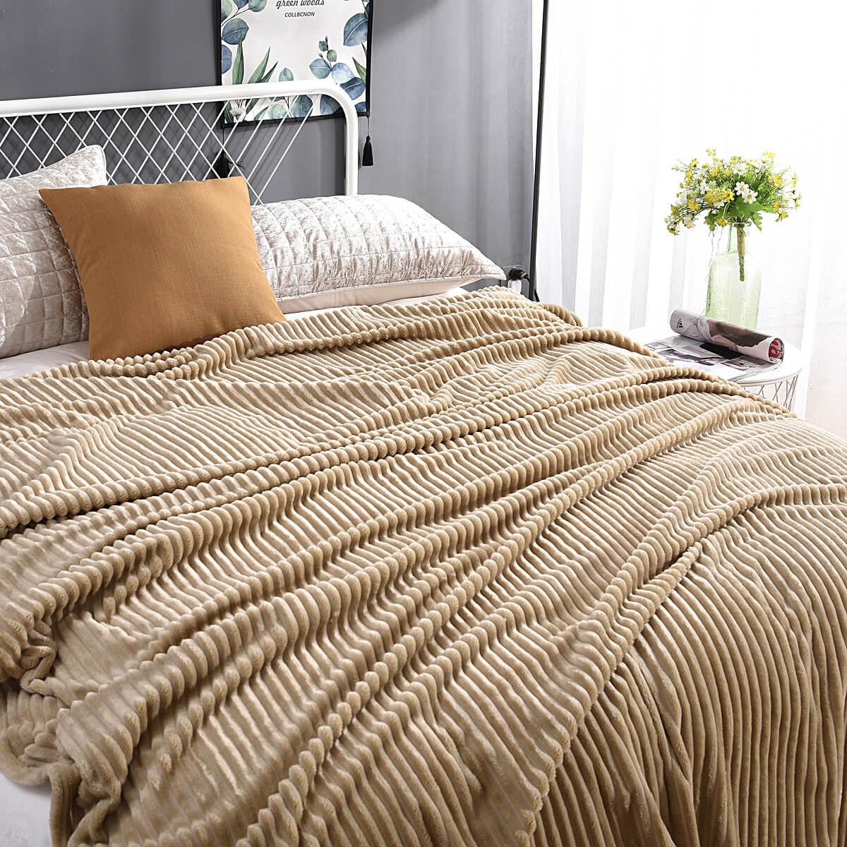 Beige Samt-Fleece-Decke auf einem Bett mit Kissen und Blumenvasen