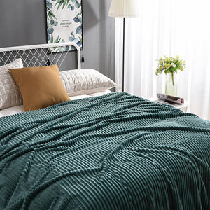Grüne Samt-Fleece-Decke auf einem Bett mit Kissen und Gemälde