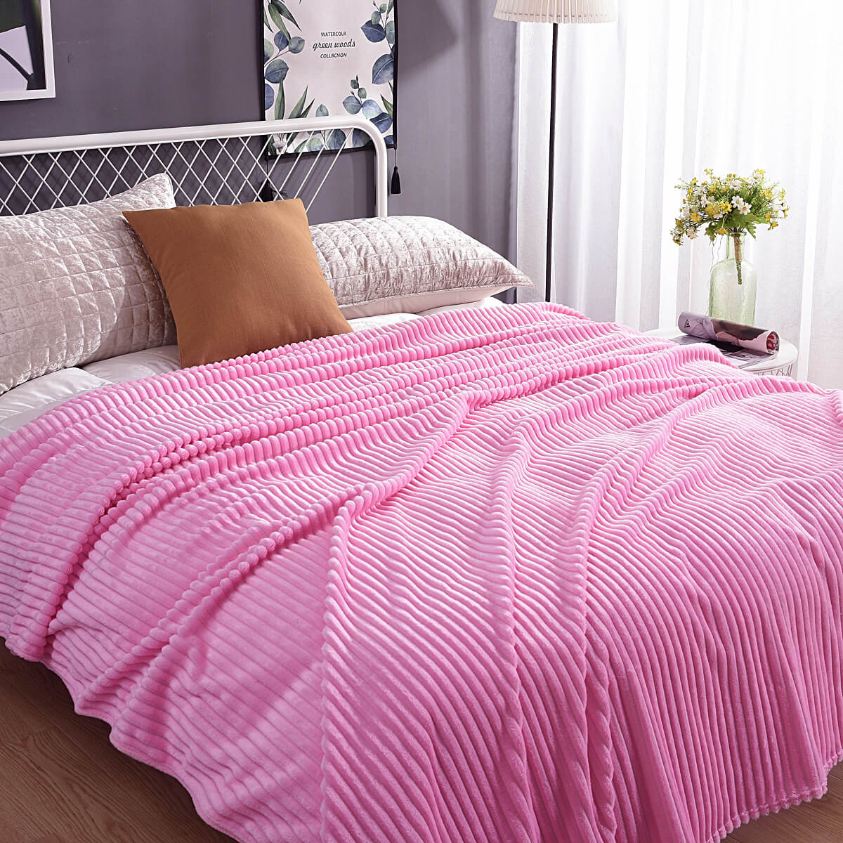 Rosa Samt-Fleece-Decke auf einem Bett mit Kissen und Pflanzen-Dekoration