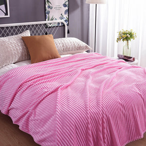 Rosa Samt-Fleece-Decke auf einem Bett mit Kissen und Pflanzen-Dekoration