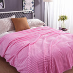Rosa Samt-Fleece-Decke auf einem Bett mit Kissen und Pflanzen-Dekoration