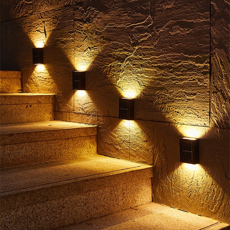 Außenlampen beleuchten die Steintreppe nachts mit warmem Licht.