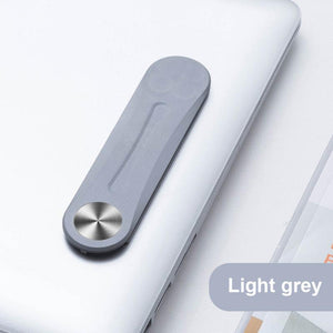 Graue magnetische Klammer, die an einem Laptop befestigt ist
