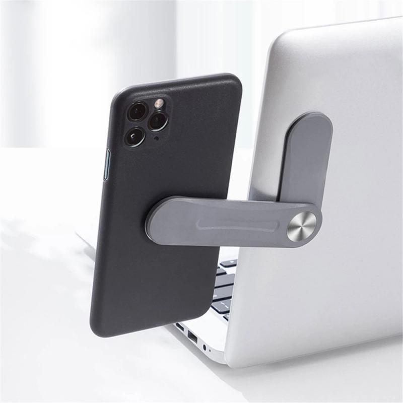 Telefon mit grauem MagnetClip am Laptop befestigt.