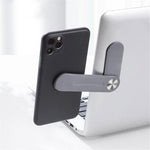 Telefon mit grauem MagnetClip am Laptop befestigt.