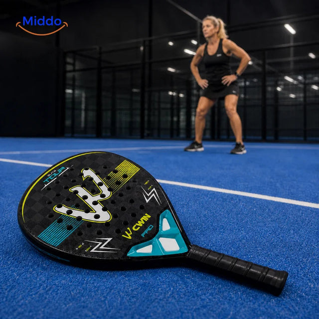ApexTour Padelschläger: Schläger auf dem Platz mit einer Spielerin im Hintergrund.