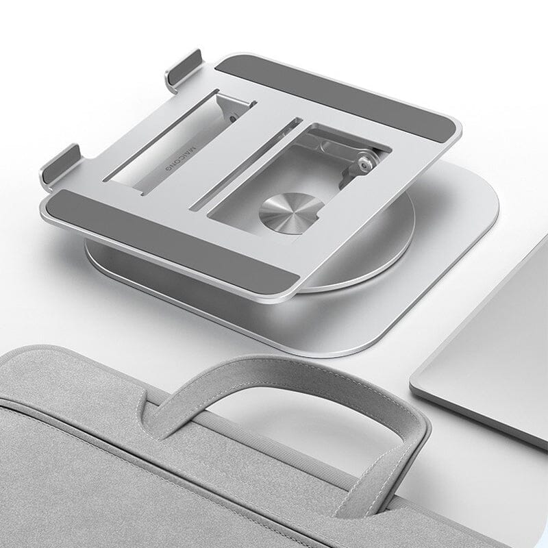 Klappbarer Laptopständer neben Tasche und Laptop auf weißer Oberfläche.