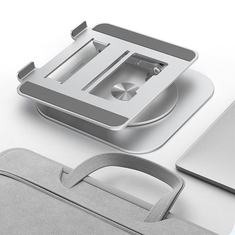 Klappbarer Laptopständer neben Tasche und Laptop auf weißer Oberfläche