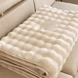 Gefaltener beiger Möbelbezug auf einem beigen Sofa