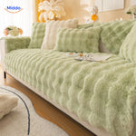 Hellgrüne Sofaabdeckung mit Kissen auf einem Sofa.