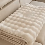 Gefaltener beiger Möbelbezug auf einem beigen Sofa