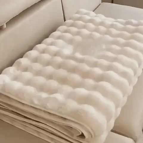 Gefaltener beiger Möbelbezug auf einem beigen Sofa
