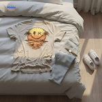Beige Smileywave T-Shirt mit Druck, flach auf dem Bett liegend - www.middo.de