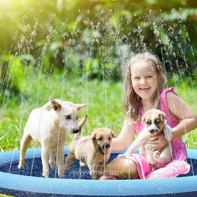 Mädchen und Hunde spielen auf einer Wassermatte im Garten.