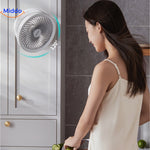 Frau genießt den Ventilator in der Küche mit ihrem wehenden Haar.