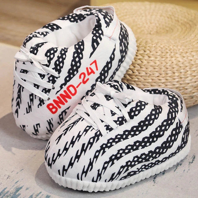 wei mit schwarzen Streifen Slippersneaker und weißen Schnürsenkeln, Rattan-Untergrund.